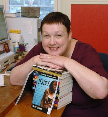 Valerie Sherrard leaning on stack of books