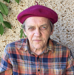 Headshot of Guy Arsenault in raspberry-coloured beret