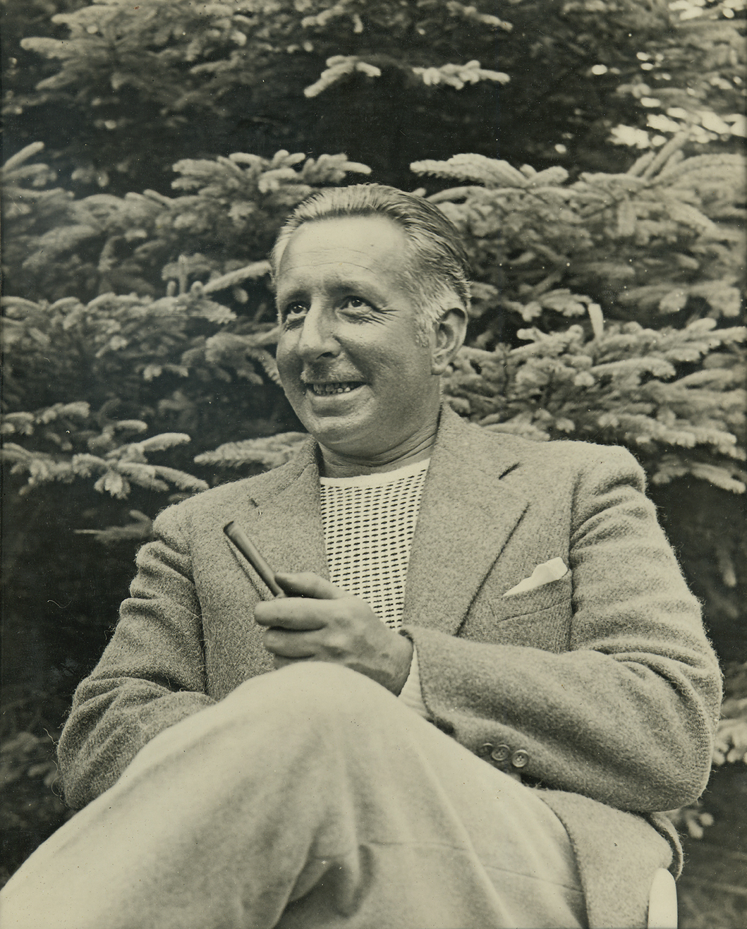 Louis Arthur Cunningham, seated outdoors, with his pipe in his hand